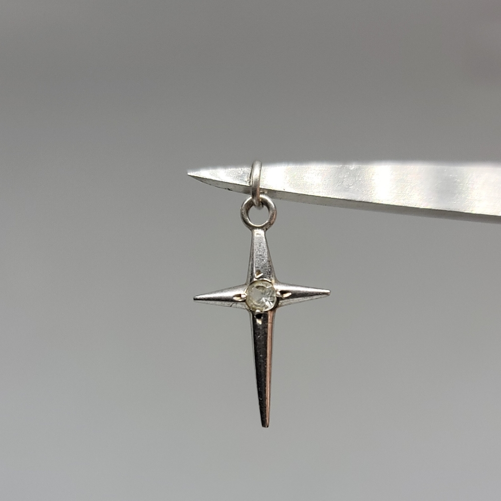 Sterling silver cross charm with a white stone